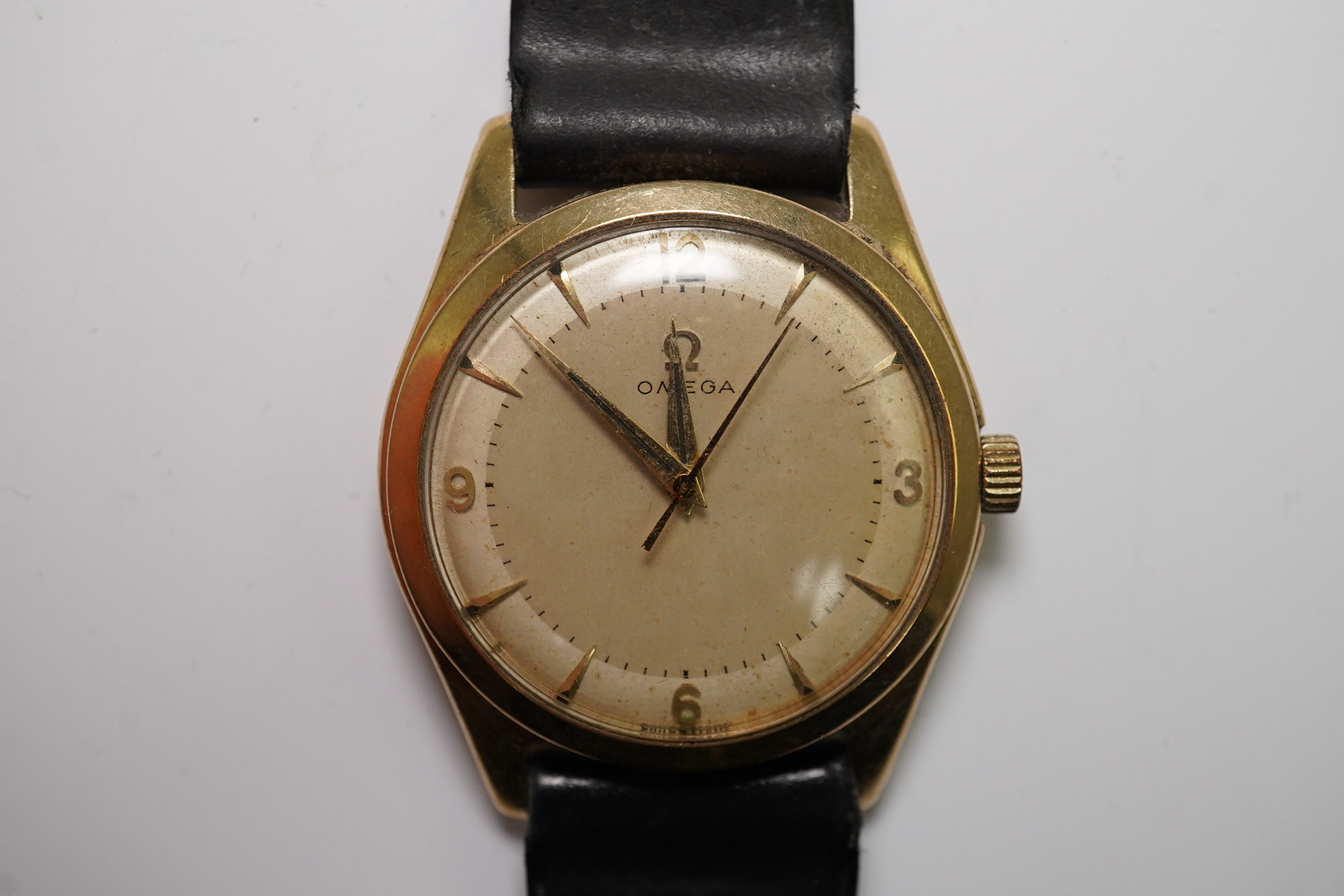 A gentleman's 1950's 9ct gold Omega manual wind wrist watch, with baton and Arabic numerals, movement c.420, case diameter 34mm, on associated leather strap. Condition- poor to fair